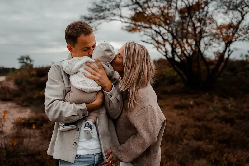 Ouders knuffelen hun baby op de heide